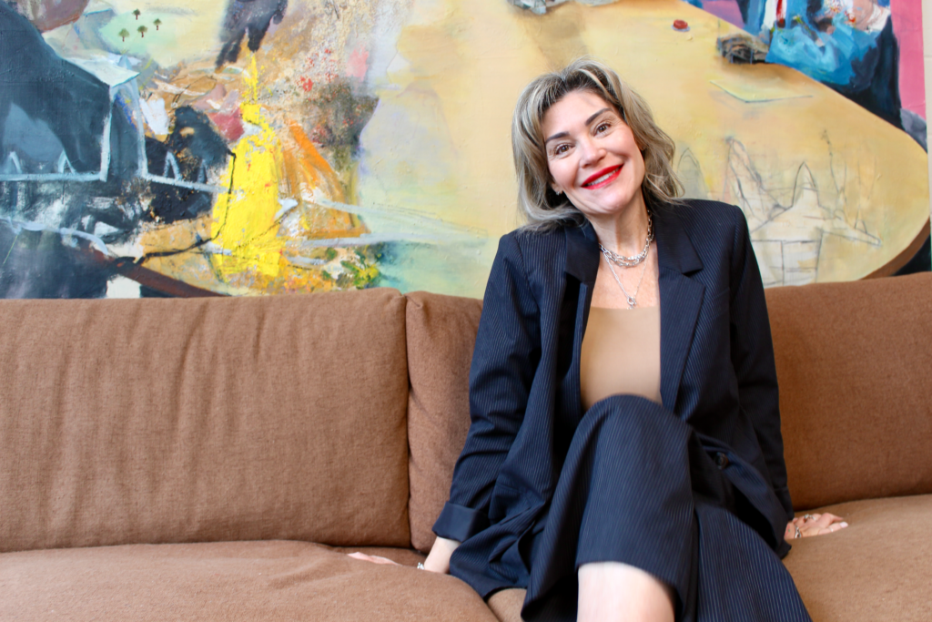 Christine Tonoli smiling while sitting on couch