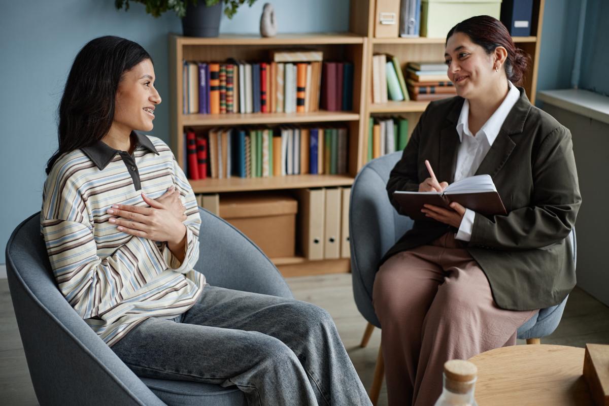 Therapist taking notes while client speaks